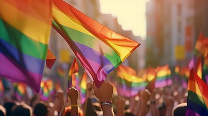 Pride community at a parade with hands raised and the LGBT flag.