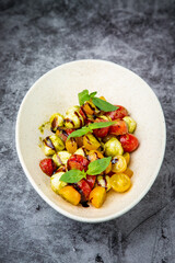  salad of yellow and red cherry tomatoes of different varieties with herbs top view