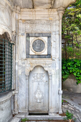 Niche at the white marble walls of Haci Mehmet Emin Aga Fountain, or Sebil, near Dolmabahce palace, Istanbul, Turkey. Text above translates: In the name of God, the most gracious, the most merciful