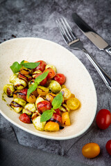  salad of yellow and red cherry tomatoes of different varieties with herbs side view