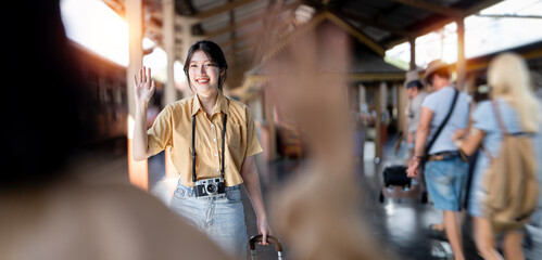Female tourist Wave to her friend Meanwhile, a friend picked her up at the train station.