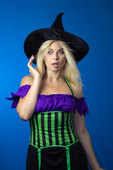 Blonde woman in black witch hat wearing costume for Halloween