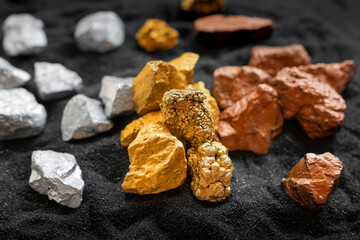 Ore gold silver and copper from the mined mines were placed on the black sand. - obrazy, fototapety, plakaty