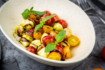  salad of yellow and red cherry tomatoes of different varieties with herbs side view