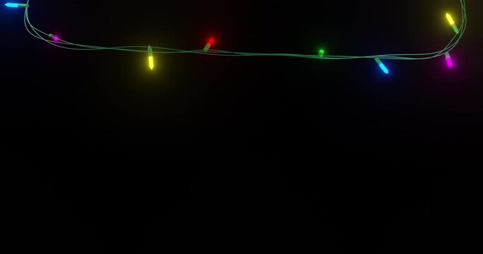 Strand of coloured christmas string lights flashing on black background, copy space