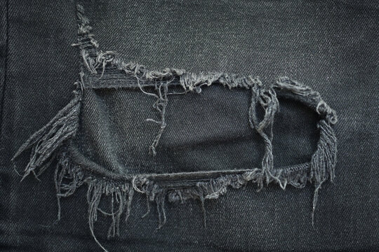 torn black danim texture background, textile of jeans fashion for clothing design