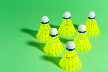 View of Line of New Shuttlecocks on Green Background As Flatlay with Copy Space.