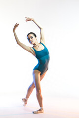 Professional Asian Japanese Female Ballet Dancer in Blue Dance Swimsuit With Lifted Hands Against White