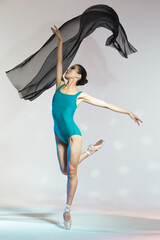 Professional Asian Japanese Female Ballet Dancer in Blue Dance Swimsuit With Lifted Hands Against White