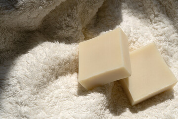 two bars of soap lie on a towel