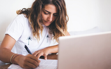 Woman sitting at table and filling out papers