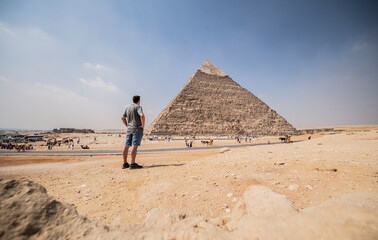 Silueta de hombre contemplando la belleza de una de las pirámides en el desierto de Guiza, viaje y turismo a aEgipto