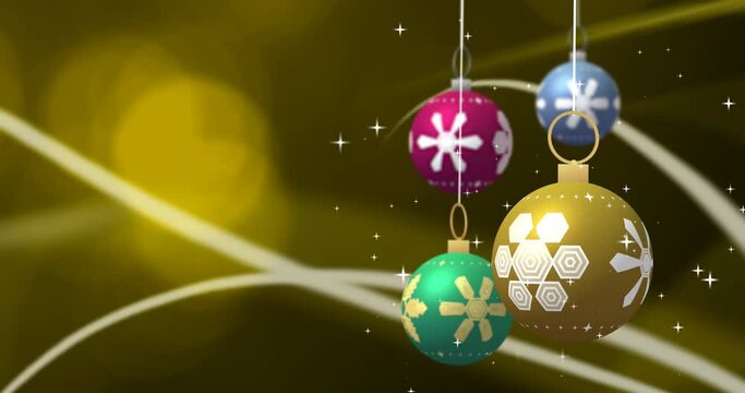 Spinning colourful christmas baubles and white stars over curves and yellow boke lights, copy space