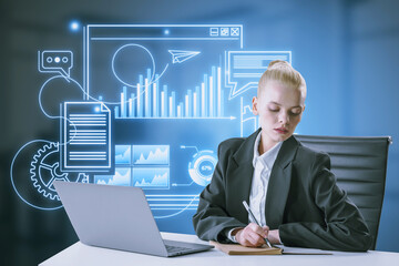 Blonde young businesswoman doing paperwork at desk with laptop and blue devices hologram on blurry office interior background. Digital marketing, social network and online service concept.
