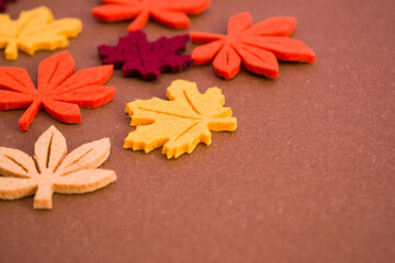Autumn leaves on brown background, copy space