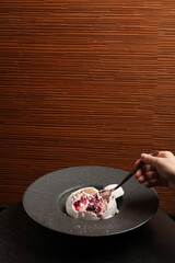 Raspberry Meringue dessert in a black plate.