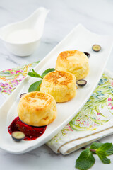 lush and tall cheesecakes with jam and mint on a white plate side view