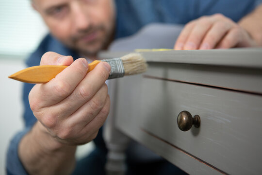 close up view of young decorator painting furniture