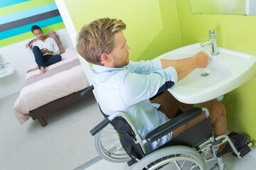 Obraz premium man in wheelchair washing hands