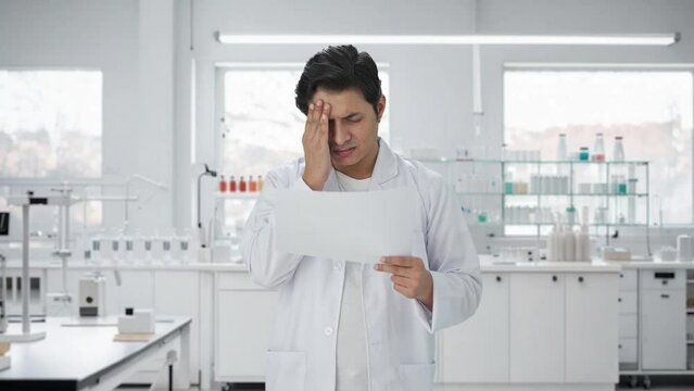 Stressed Indian scientist reading research papers