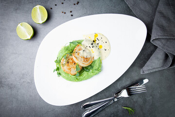 cheesecakes with creamy sauce on broccoli puree, top view