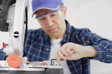 Obraz premium carpenter adjusting the mitter saw