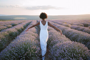 Young woman walking amist lavender field