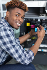 young male technician repairing digital photocopier machine