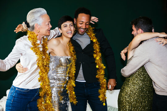 Happy family with tinsels embracing each other at new year party