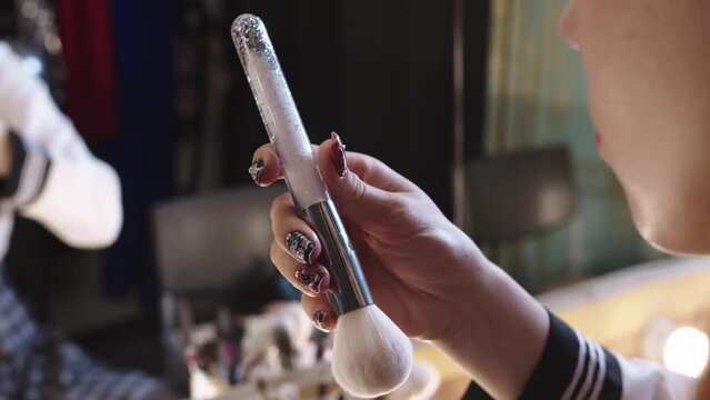 Close-up of the makeup brush in the actress hand