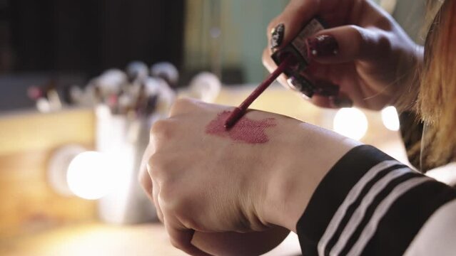 Close-up of actresss hand testing lipstick shade