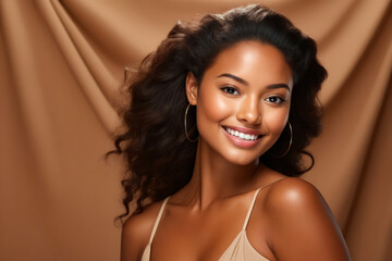 Woman with smile on her face and tan background.
