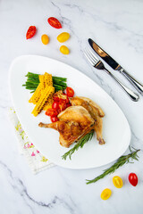 Grilled chicken with tomatoes and corn top view