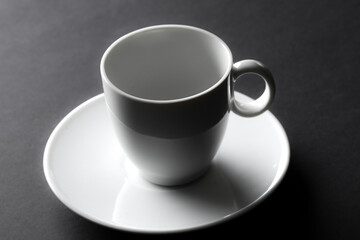 Coffee cup on a saucer. High contrast studio photograph