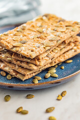 Knackebrot with sesame seeds. Wholegrain crispbread on plate on kitchen table.