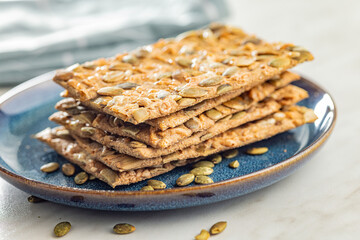 Knackebrot with sesame seeds. Wholegrain crispbread on plate on kitchen table.