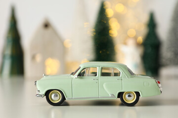 Fototapeta na wymiar Green car with New Year's decoration on the background.