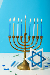 Hanukkiah and gingerbread with Jewish symbol on blue background
