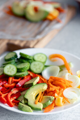 Close-up, slices of vegetables in a plate on the kitchen table.