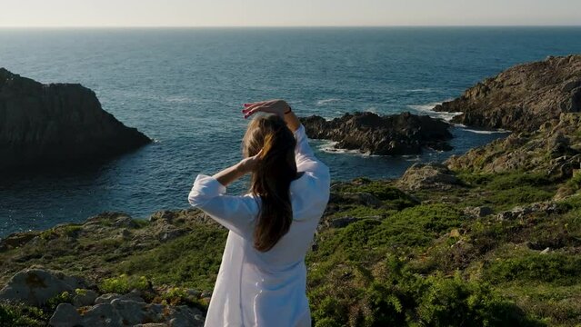 Woman Brushing Hair With Hands While Overviewing Seascape Near Ferrol In Galicia, Spain. slowmo