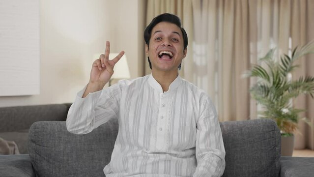 Happy Indian man showing victory sign