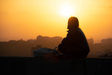 Sunset and woman. Girl against the backdrop of sunset. Orange sky and sun