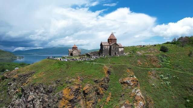 Aerial view church near Sevan in Armenia. Drone fly from Ancient church  Sevanavank monastery․ Tourists near monastery. Famous touristic place.  