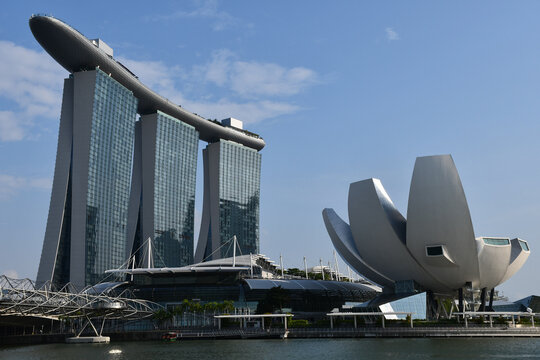 Singapore, Singapore - August 22, 2019: Marina Bay Sands, including the ArtScience Museum, designed by Moshe Safdie, with the Helix Bridge (left), designed by Cox Architecture, Architects 61 and Arup.