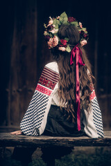 girl in Ukrainian costume sitting view from the back