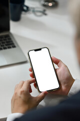 Close up man using smartphone at office desk. Empty screen for your advertising text message