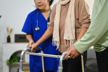 Practitioner nurse assisting senior female walking with walker. Healthcare service and rehabilitation