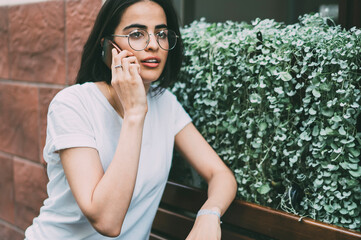 Fototapeta premium Charismatic ethnic female calling on mobile in street