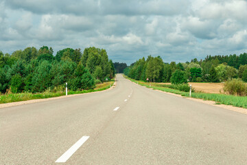 Rural landscape with asphalt road, fields and meadows