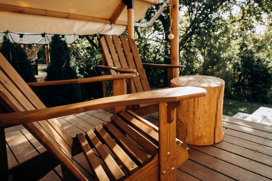 Outdoor seating area, wooden chairs and a table for eating for two in a secluded glamping area. Fresh air and health care